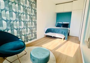 a bedroom with a bed and a chair and a table at Appartement proche Paris, Disney, Cité Descartes, Centrex in Champs-Sur-Marne