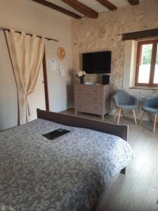 Un dormitorio con una cama, una cómoda y un televisor. en La Maison Genevier - Chambre Marguerite, en Montreuil-en-Touraine 11 fotos más