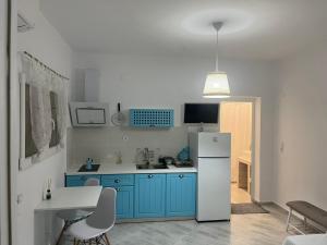 a kitchen with blue cabinets and a white refrigerator at Casa Sonia in Áyios Pétros