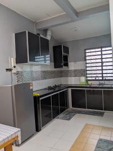 a kitchen with stainless steel appliances and a window at DHIA Homestay Gurun in Kampung Gurun