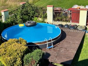 duży niebieski basen na drewnianym tarasie w obiekcie Apartament na Górce w Międzybrodziu Bialskim
