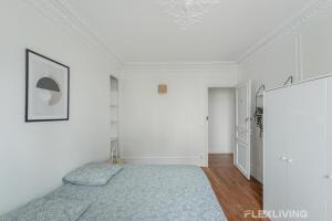 a bedroom with white walls and a bed with a blue blanket at Flexliving - Room - Henri Sellier - Suresnes 92 in Suresnes