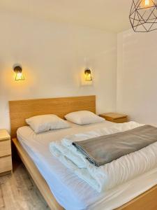 a bedroom with a large bed with two pillows at Les Dunes, Maison proche plage in Saint-Lunaire +17 photos