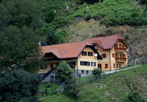 une grande maison sur le flanc d'une colline dans l'établissement Tourist Farm Arbajter, à Resnik