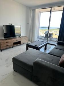 a living room with a couch and a flat screen tv at Grand Sapphire Resort & Casino with sea view in İskele