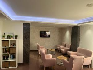 a waiting room with chairs and a tv on a wall at Hotel Nuevo Lanzada in A Lanzada