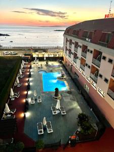 an overhead view of a resort with a swimming pool and the ocean at Hotel Nuevo Lanzada in A Lanzada