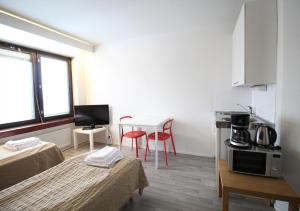 a room with two beds and a table and a kitchen at Forenom Apartments Rauhankatu 16 in Lahti
