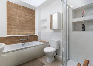 a bathroom with a toilet and a tub and a sink at The old ice cream parlour in Penzance +6 photos