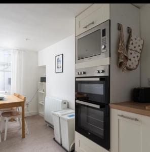 a kitchen with a microwave above an oven at The old ice cream parlour in Penzance