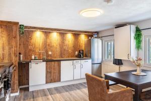 a kitchen with wood paneling and a table and a kitchen with white cabinets at Feichtenhäusl app 2 in Westendorf