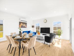 ein Esszimmer und ein Wohnzimmer mit Tisch und Stühlen in der Unterkunft Brand New Comfy Home 4Bedroom designer furniture in Springfield Lakes