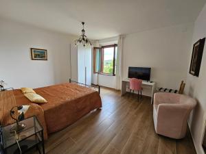 a bedroom with a bed and a chair and a desk at Residenza Albalonga in Castelnuovo Berardenga