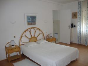 a bedroom with a large white bed and two tables at Appartement cosy à Saint-Raphaël - 65 m² - Jardin privé in Saint-Raphaël