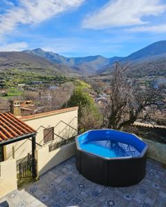 a hot tub sitting on the side of a house at La Fortaleza Apartamentos Rurales in Hervás