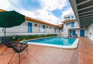 a swimming pool with an umbrella next to a building at Family Friendly Beach Escape with pool and parking - M41 in Hollywood