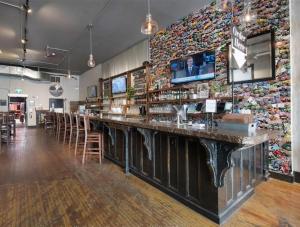 a bar in a restaurant with a wall covered in flowers at Heart & Hops Brewery Suites in Kingsville