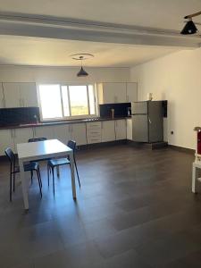a kitchen with a table and chairs in a room at Appartement a saidia de 100m2 familiale in Saidia  +4 photos