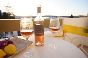 two glasses of wine and a bottle on a table at Celestial by Mike in Parikia