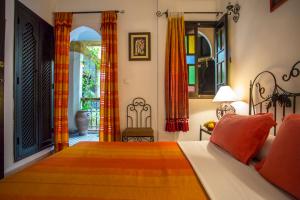 a bedroom with a bed with orange pillows at Riad Jnane Mogador in Marrakech