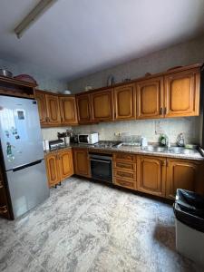 a kitchen with wooden cabinets and a white refrigerator at La Cuesta House in Castell de Ferro