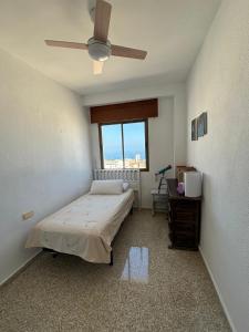 a bedroom with a bed and a ceiling fan at La Cuesta House in Castell de Ferro
