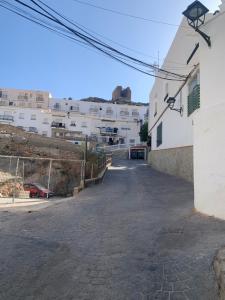 an empty street with white buildings in the background at La Cuesta House in Castell de Ferro
