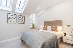 a white bedroom with a large bed and windows at Dragon Suites - Yukina Suite - 2 bed city centre house with garden in Edinburgh