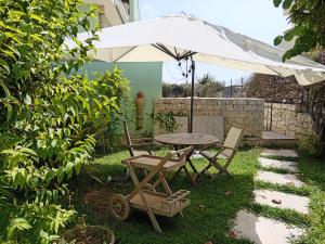 a table and chairs and an umbrella in the yard at Verde Mare Isola in Carrozziere