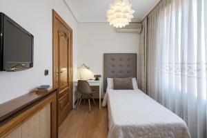 a bedroom with a bed and a desk and a tv at Hotel Eurowest in Salamanca
