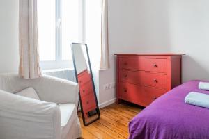a bedroom with a bed and a dresser and a mirror at Appartement rénové cœur de ville Les Sables - 4 personnes in Les Sables-dʼOlonne