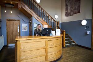 a woman sitting at a counter with a laptop at White Hart, Newmarket by Marston's Inns in Newmarket
