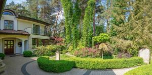 a house with a garden with bushes and trees at Luxury villa indoor pool Warsaw in Magdalenka