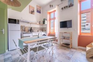 a kitchen with a table and chairs and a television at Marseille soleil urbain in Marseille