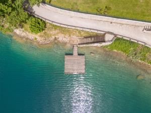 an aerial view of a dam in the water next to a road at Villa Ledro with Private Dock - Sauna - Hot Tub in Molina di Ledro +30 photos