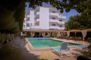 a swimming pool in front of a large building at Hotel Sorrente in Golem