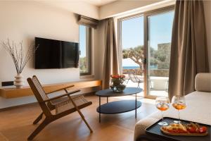 a living room with a couch and a table with wine glasses at Akre Villas in Ierapetra