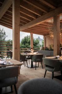 a restaurant with tables and chairs and a large window at Presulis Hideaway Apartments & Restaurant in Fi&egrave;