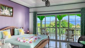 Un dormitorio con una cama con paredes rosas y una gran ventana. en Villa Hortensia, en La Digue