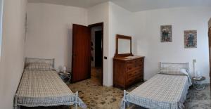ピエトラサンタにあるCasa Nildoのベッドルーム1室(ベッド2台、ドレッサー、鏡付)