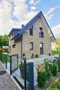 a brick house with a black fence at Vila Omama in Palanga