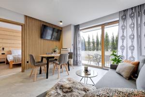 a living room with a couch and a table at Apartamenty Księżycowe SPA - Tatra View - Golden Apartments in Zakopane