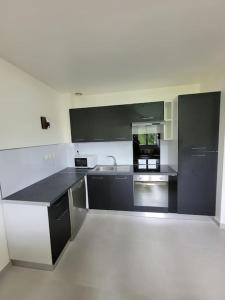a kitchen with black and white counters and appliances at T5 - Coup de Soleil in Juvignac
