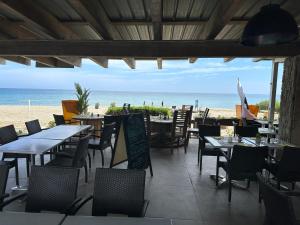 ein Restaurant mit Tischen und Stühlen am Strand in der Unterkunft Les Marines in San-Nicolao + 5 Fotos