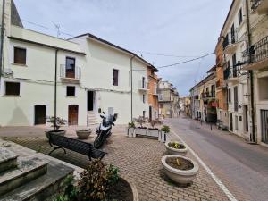 a street with a motorcycle parked on a cobblestone street at Dimore Rosantò in Palombaro