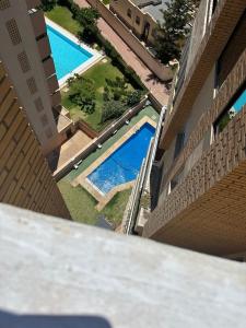 widok na dwa baseny w budynku w obiekcie ESTUDIO ÁTICO En URBANIZACIÓN ROQUETAS DE MAR w mieście Roquetas de Mar