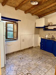 a kitchen with blue cabinets and a tile floor at CasaCalma Hotel Boutique in Tilcara