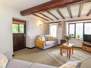 ein Wohnzimmer mit Sofa und Fernseher in der Unterkunft Addylea Cottage in Windermere