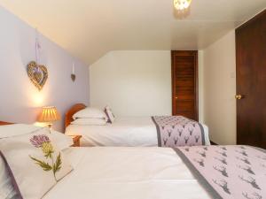 zwei Betten in einem Zimmer mit zwei Betten sidx sidx sidx sidx in der Unterkunft Addylea Cottage in Windermere
