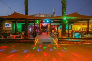 un restaurante con luces verdes y gente sentada en mesas en Hotel Baba, en Gümbet 9 fotos más